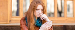 Woman looking at her phone with a concerned expression