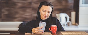 Young woman using smart phone at a cafe table